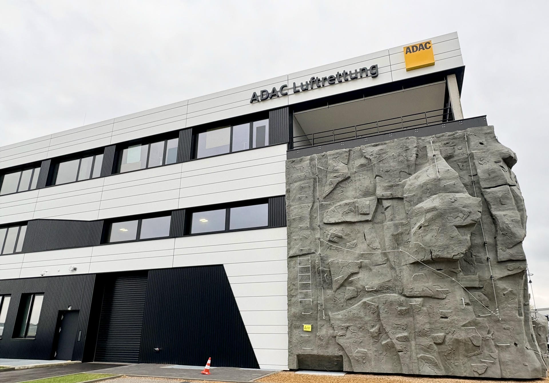 Außenbereich des ADAC Luftrettung Campus mit Gebäude und Kletterwand