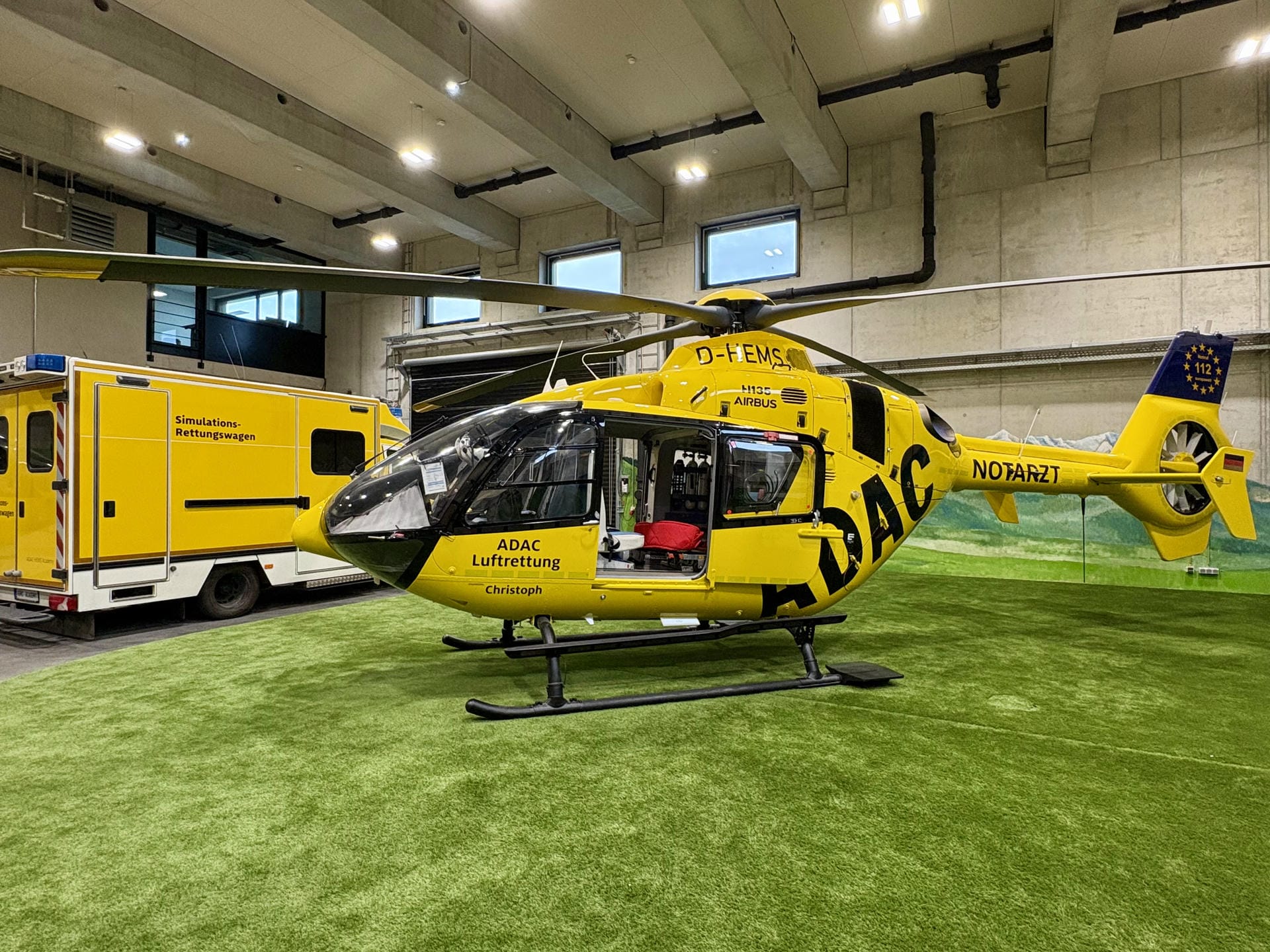 Trainingshalle mit Hubschrauber-Modell und Rettungswagen-Simulator
